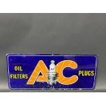 A small AC Oil Filters and Plugs enamel sign with central spark plug image, 21 x 9".