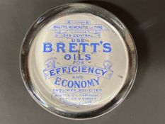 A Brett's Oils glass paperweight.