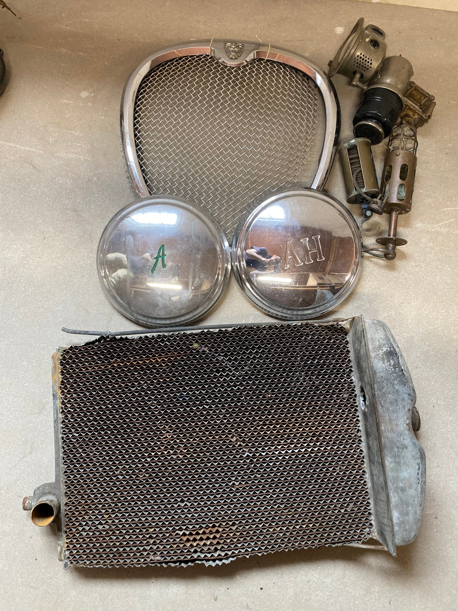 An Austin 7 radiator core, a Jaguar grille, two inspection lamps etc.