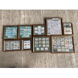 A collection of framed and glazed groups of motoring themed cigarette and trade cards.