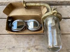 A boxed pair of Melton Mk. VIII goggles plus an exterior light from a garage.