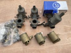 A set of three bronze bodied SU carburettors, each numbered 661, with a box of new components