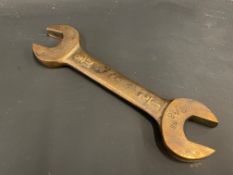 A bronze double open ended spanner, 1/2" and 9/16", probably a fuel tank or pump spanner, as being