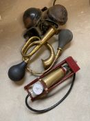 A pair of wind tone horns, two modern brass horns and a brass foot pump.