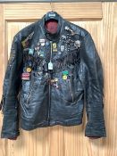 A fringed leather jacket covered in many pop music badges.