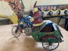 A contemporary and decorative model of Father Christmas sat on a motorcycle combination