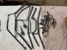 A selection of five motorcycle handlebars and assorted mirrors.