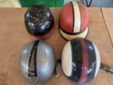 Four assorted early race helmets.