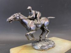 A Desmo accessory mascot in the form of a horse and jockey, mounted on an onyx base.