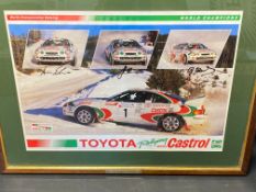 A framed and glazed World Championship Rally photograph signed by three drivers, all rallying with a
