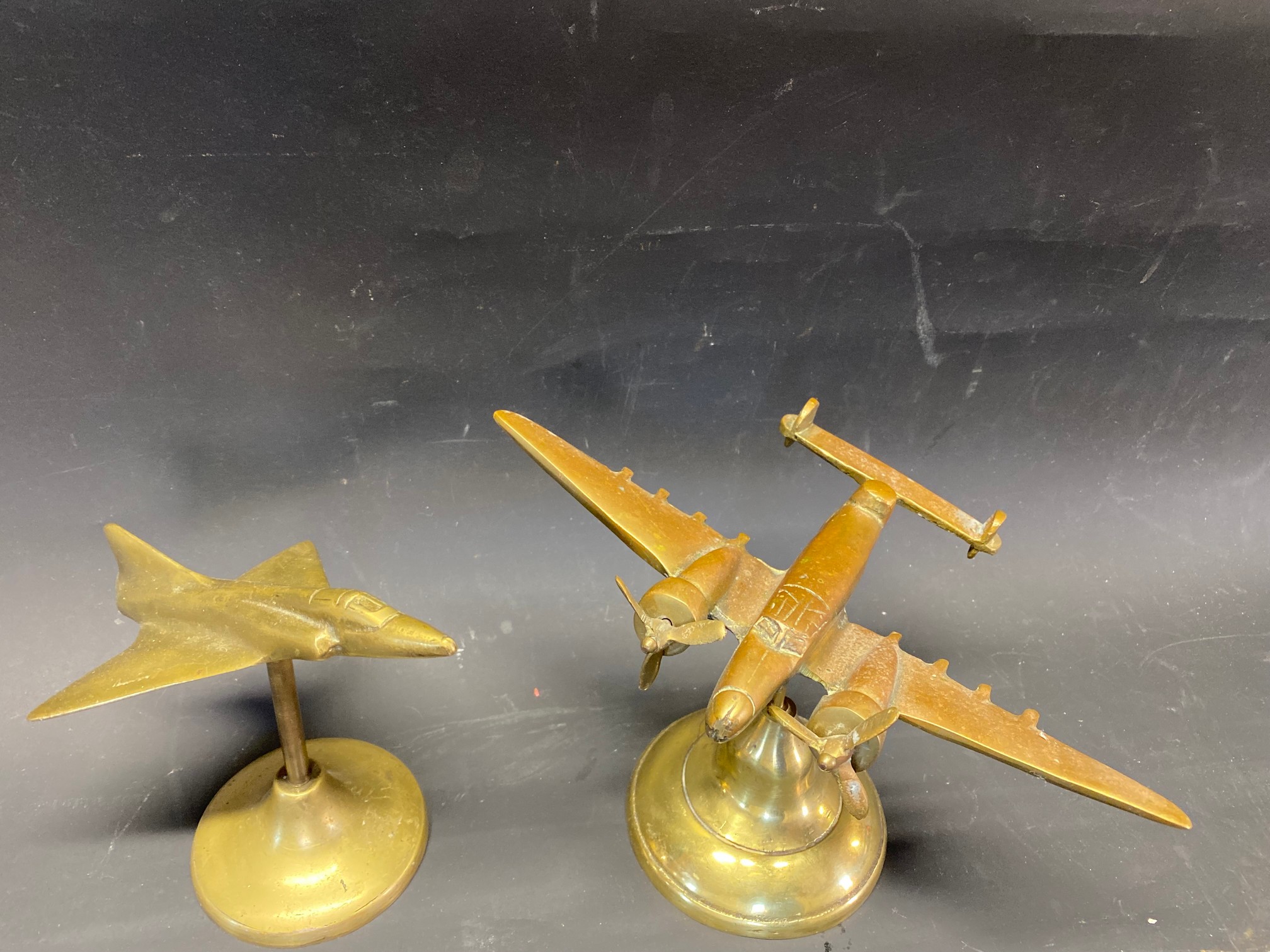 Two mascots/desk pieces the form of a brass aeroplanes, a Lockheed Hudson and a Delta winged jet.
