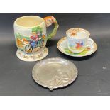 A Crown Devon musical jug depicting a couple on a tandem, a cup and saucer depicting cyclists and