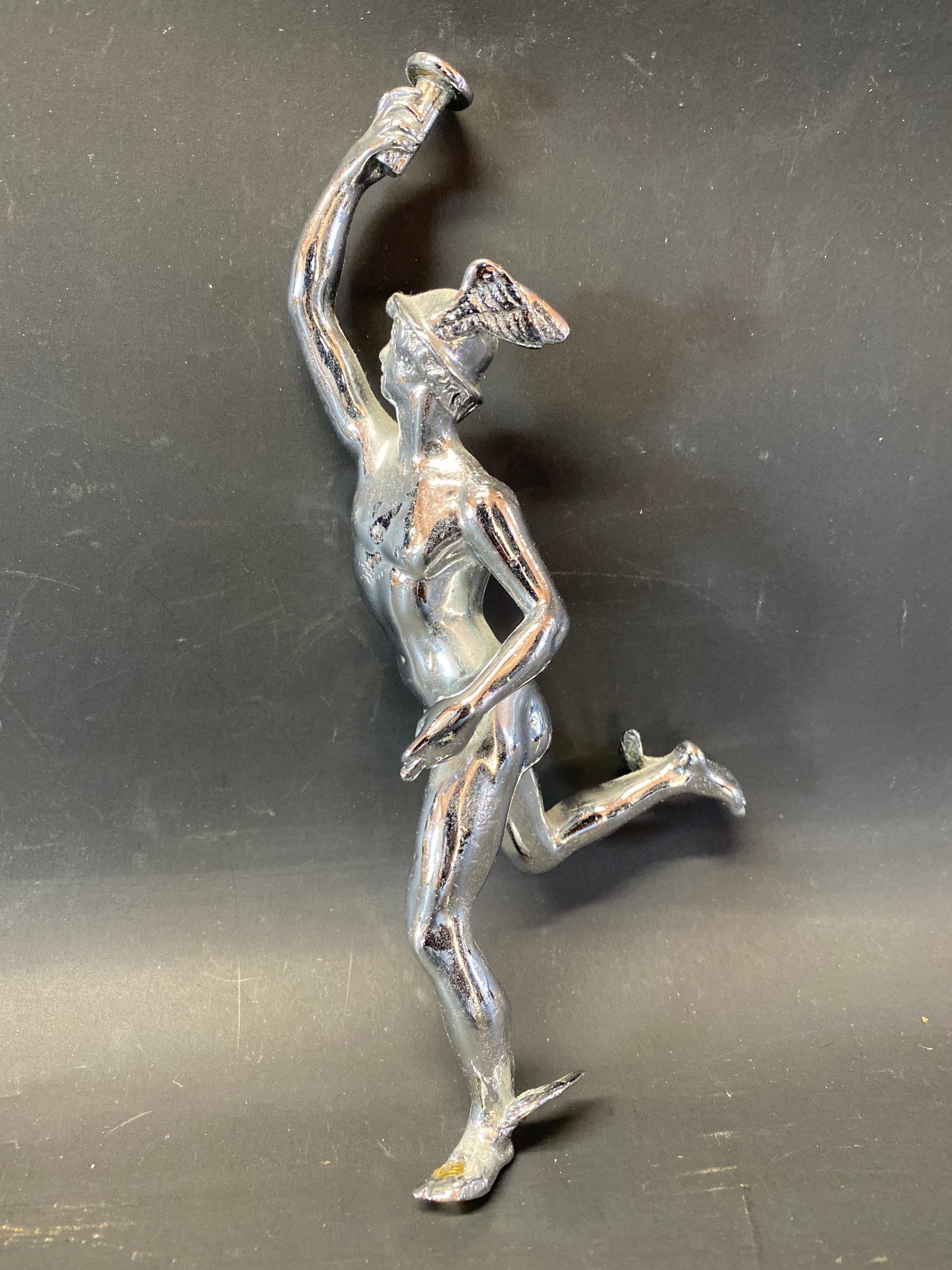 A chrome plated car accessory mascot in the form of Mercury.