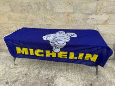 A large Michelin garage forecourt banner with Mr. Bibendum motif.