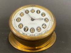 An Edwardian brass sloping backed eight day car clock.