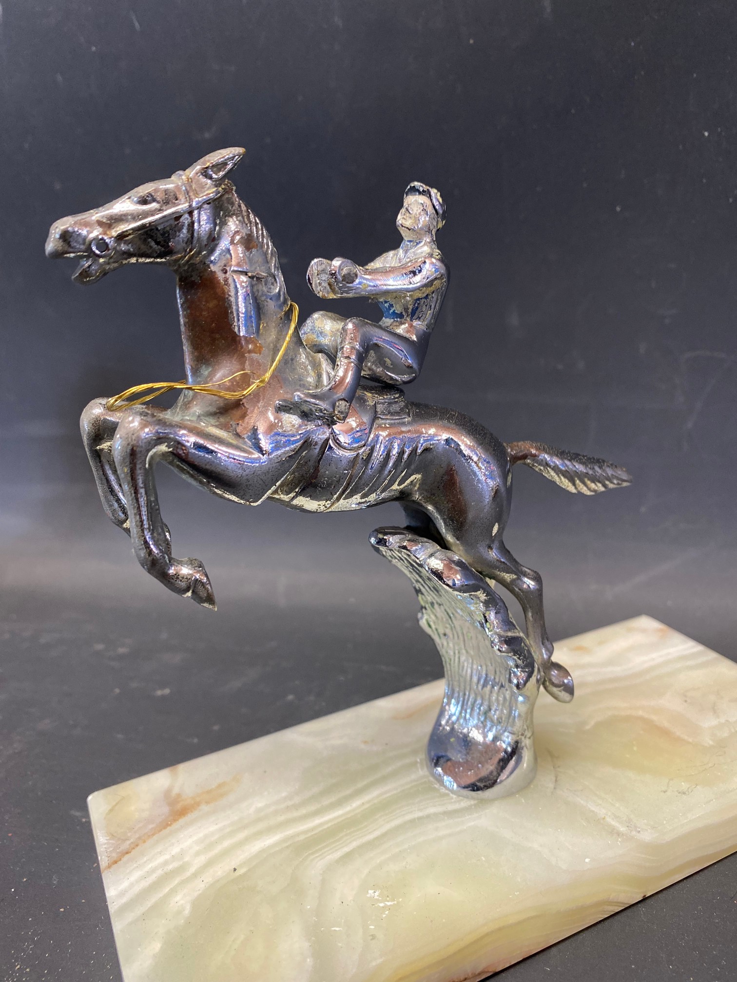 A Desmo accessory mascot in the form of a leaping horse with detachable jockey, mounted on an onyx