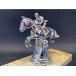 A car accessory mascot in the form of a jumping horse and jockey, mounted on an onyx base.
