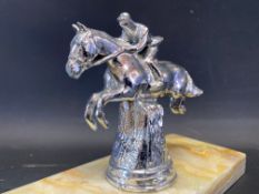 A car accessory mascot in the form of a jumping horse and jockey, mounted on an onyx base.