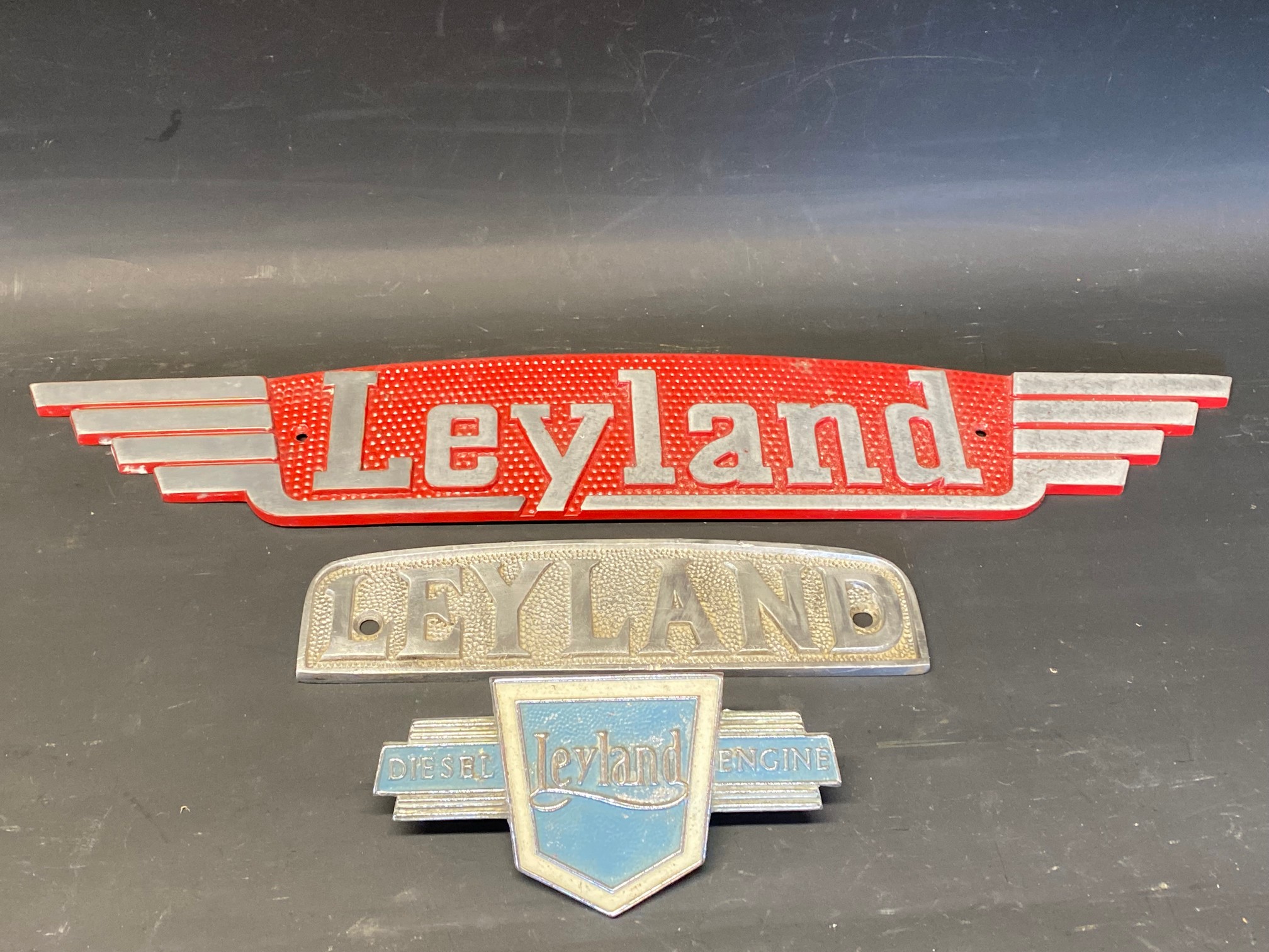 Three Leyland commercial vehicle name plates.