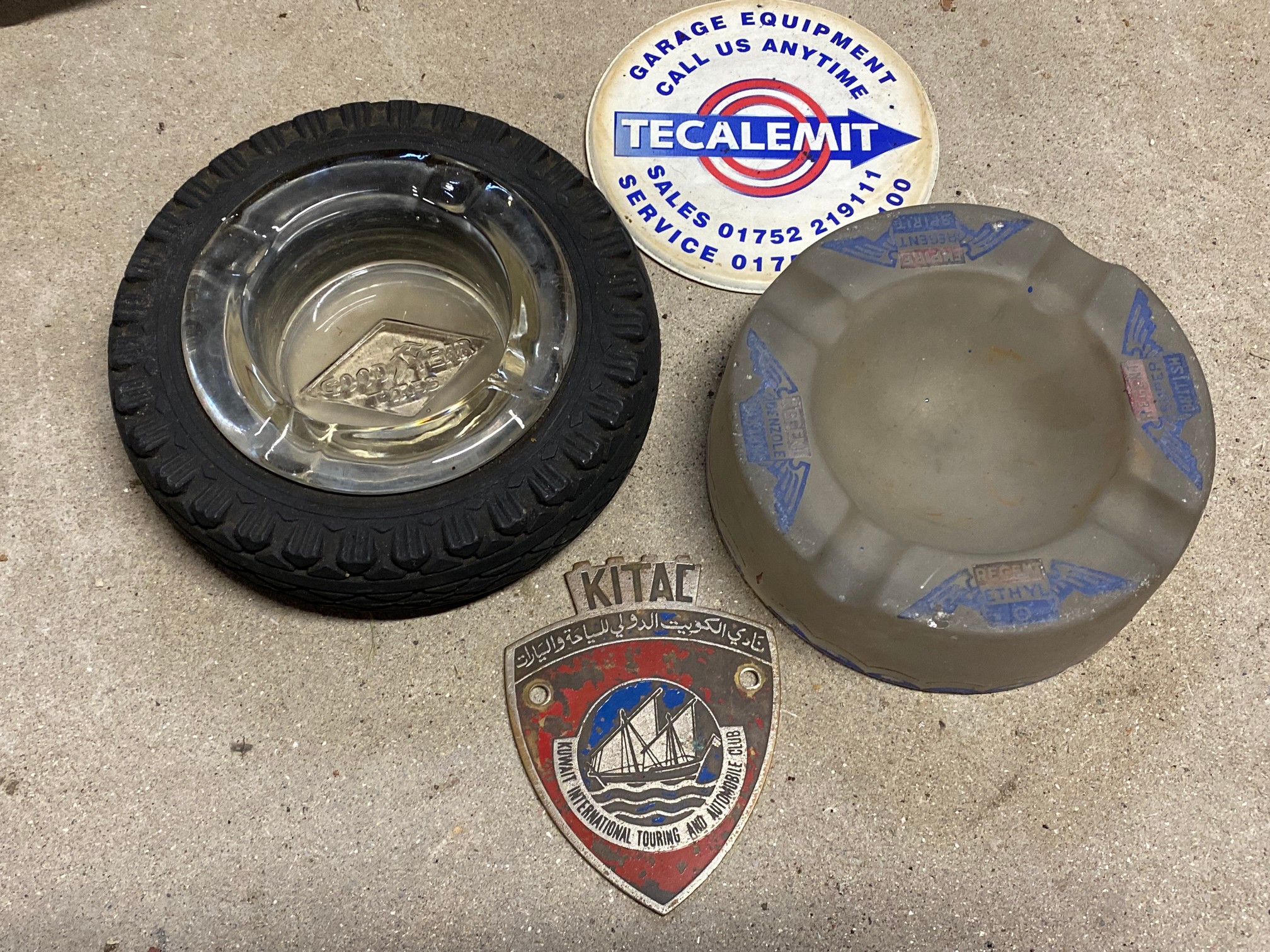 A Goodyear tyre ashtray, a Regent glass ashtray, a Tecalemit coaster and a Kuwait International