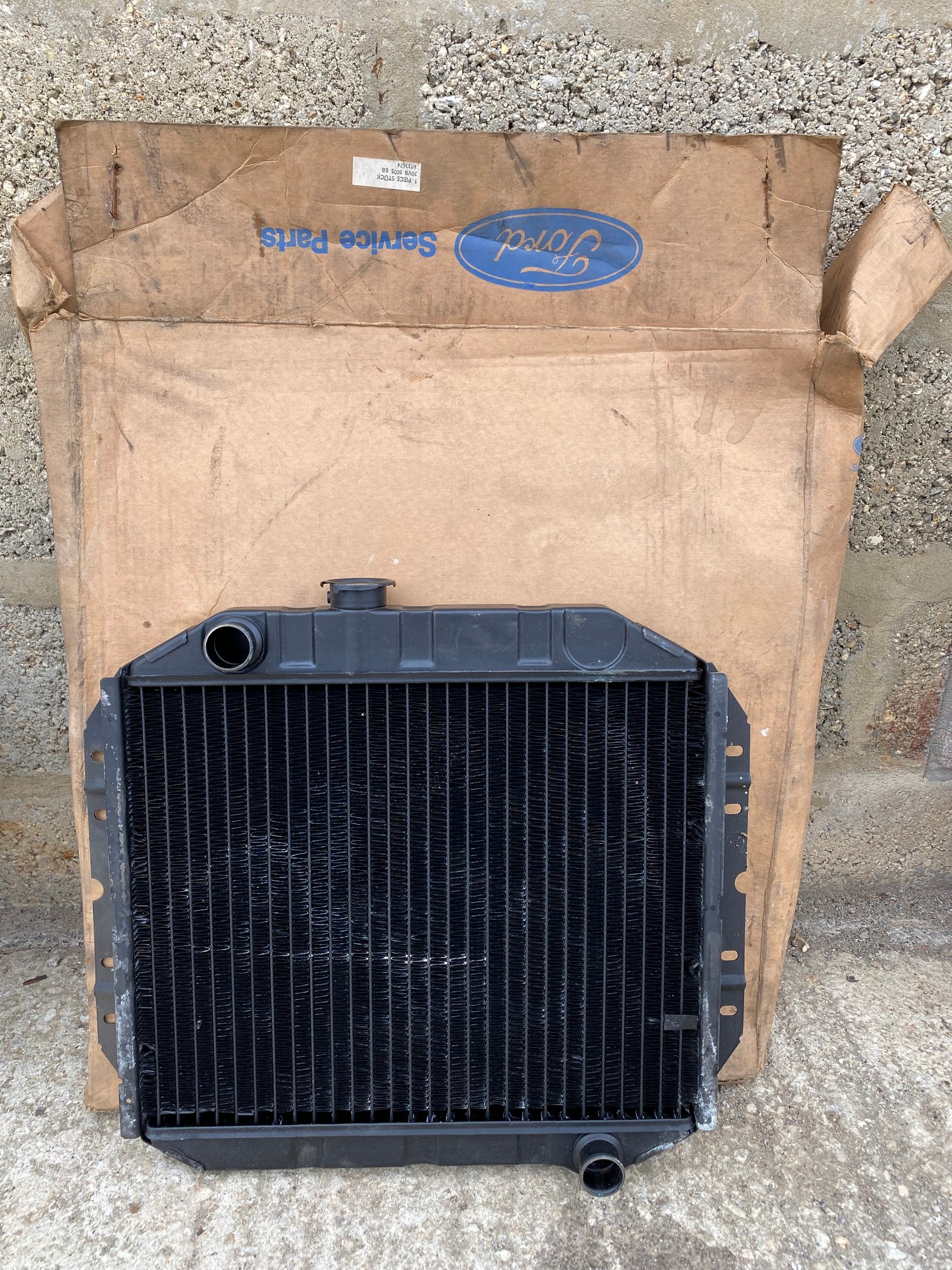 A new old stock Ford Escort radiator in original packaging.