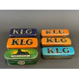 Six KLG and Sphinx spark plug tins, four with contents.