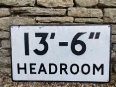 A metal road sign warning of a 13ft 6" head room limitation.