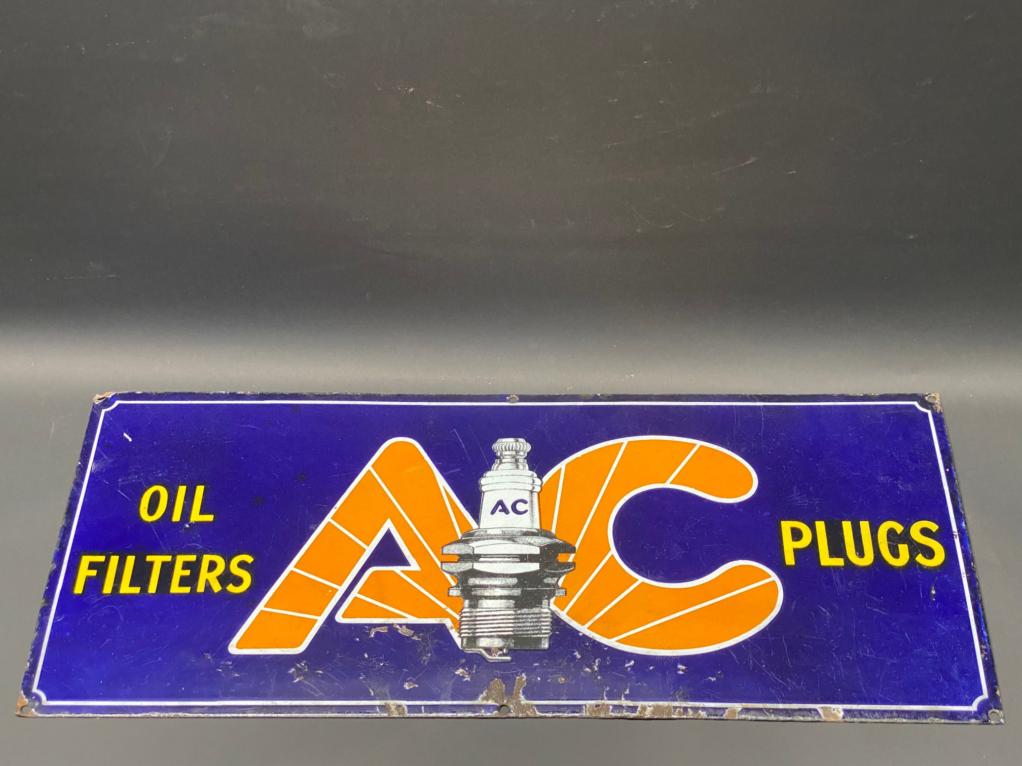 An AC Oil Filters and Plugs rectangular enamel sign, 21 x 9".