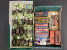 A quantity of spark plugs including Pacy, AC Titan etc. plus a tray of empty spark plug packaging.