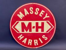 An aluminium circular sign advertising Massey Harris, 21" diameter.