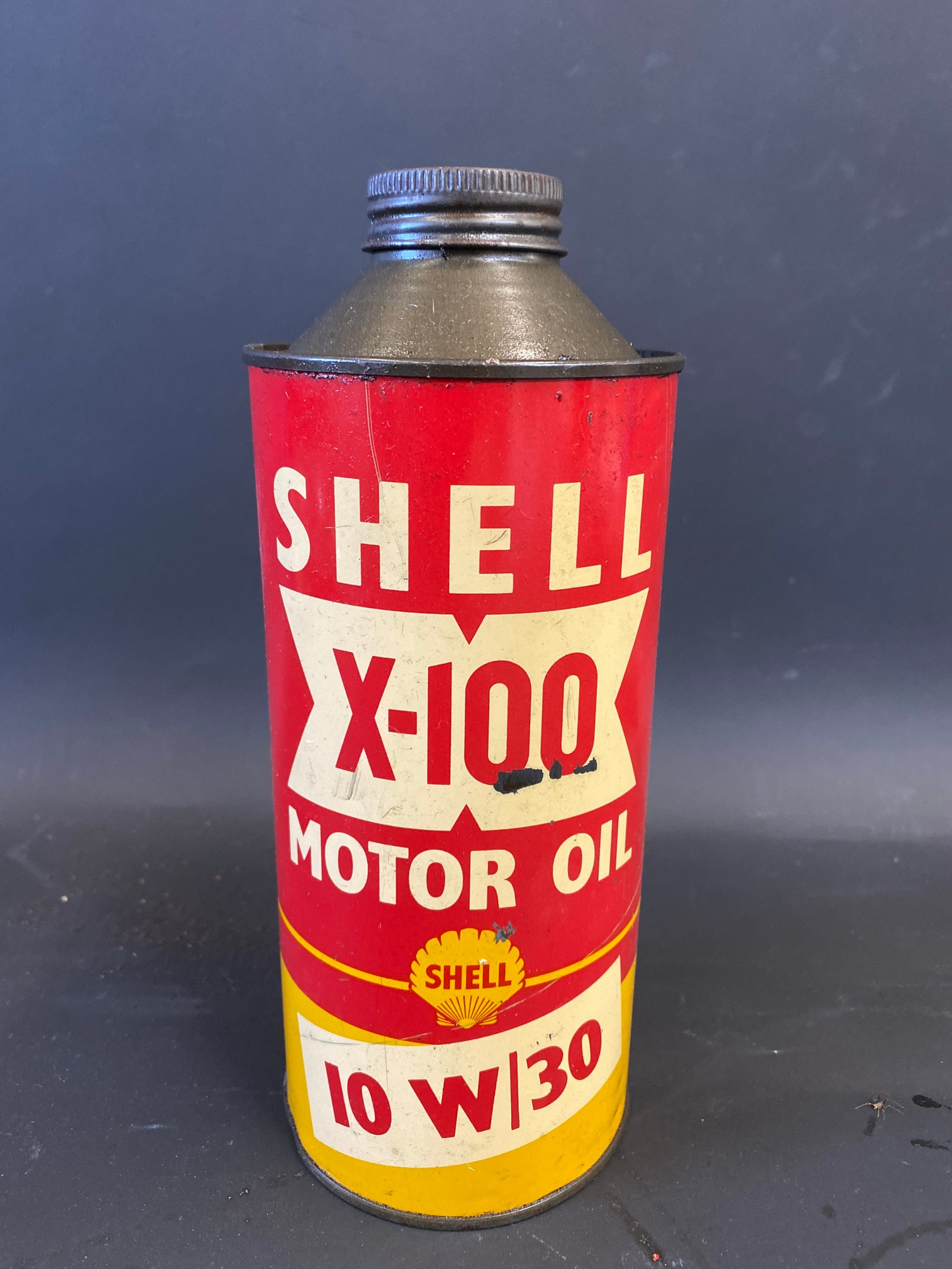 A Shell X-100 Motor Oil cylindrical quart can.