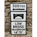 A cast metal road sign Warning of a low bridge in 300 yards.