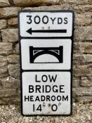 A cast metal road sign Warning of a low bridge in 300 yards.