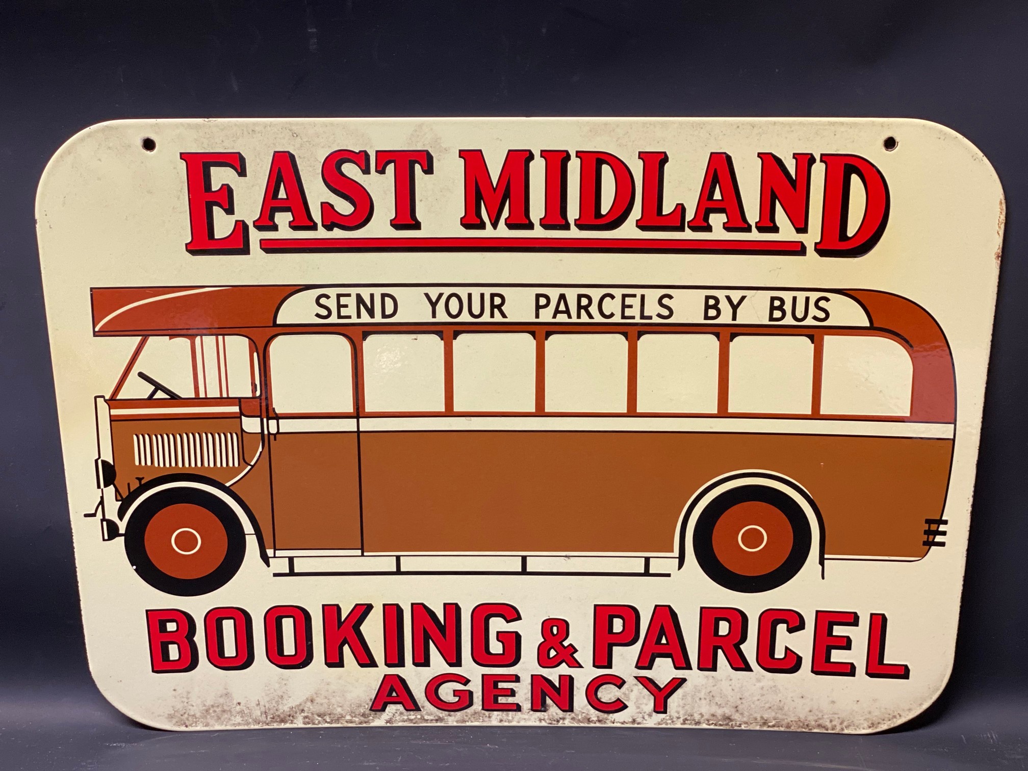An East Midland Booking and Parcel Agency pictorial double sided enamel sign depicting a vintage bus