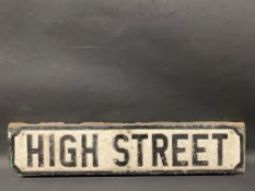 A cast metal road sign for High Street, mounted on a piece of wood, 30 1/2 x 7".