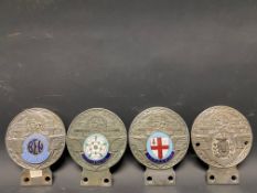 Four St. Christopher car badges, each with an enamel disc including The Motor and Cycle Trades