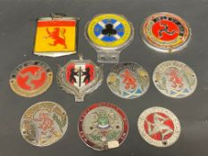 A tray of mostly Scottish and Isle of Man car badges.