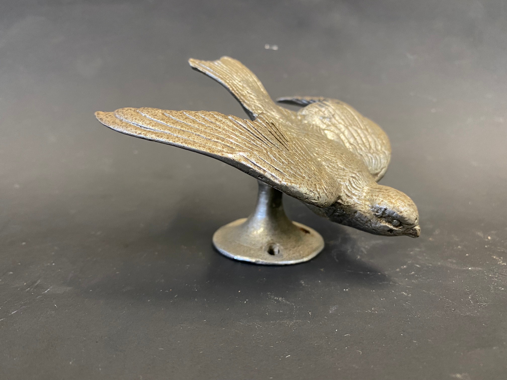An accessory car mascot in the form of a swallow in flight.