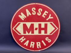 An aluminium circular sign advertising Massey Harris, 21" diameter.