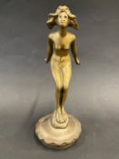 A brass accessory car mascot in the form of a female nude leaning forward, with her arms outstetched