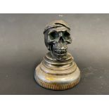 An AEL accessory car mascot in the form of a small yet well-detailed skull, nickel plated bronze.