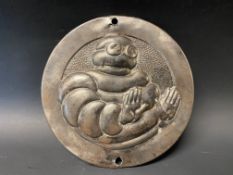 A circa 1940 Michelin circular embossed plaque depicting Mr Bibendum (from a furnace), 5" diameter.