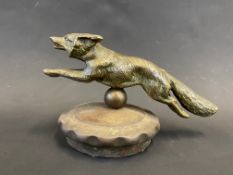 A well-detailed car accessory mascot in the form of a running fox, mounted on a radiator cap.