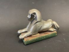 A recumbant Sphinx accessory car mascot, display base mounted.