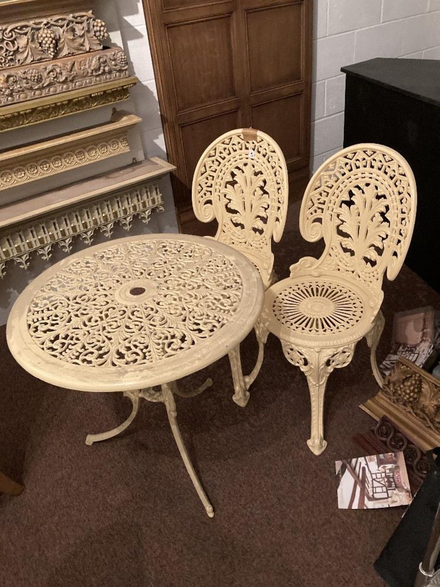 Ornate metal framed circular table and 2 chairs