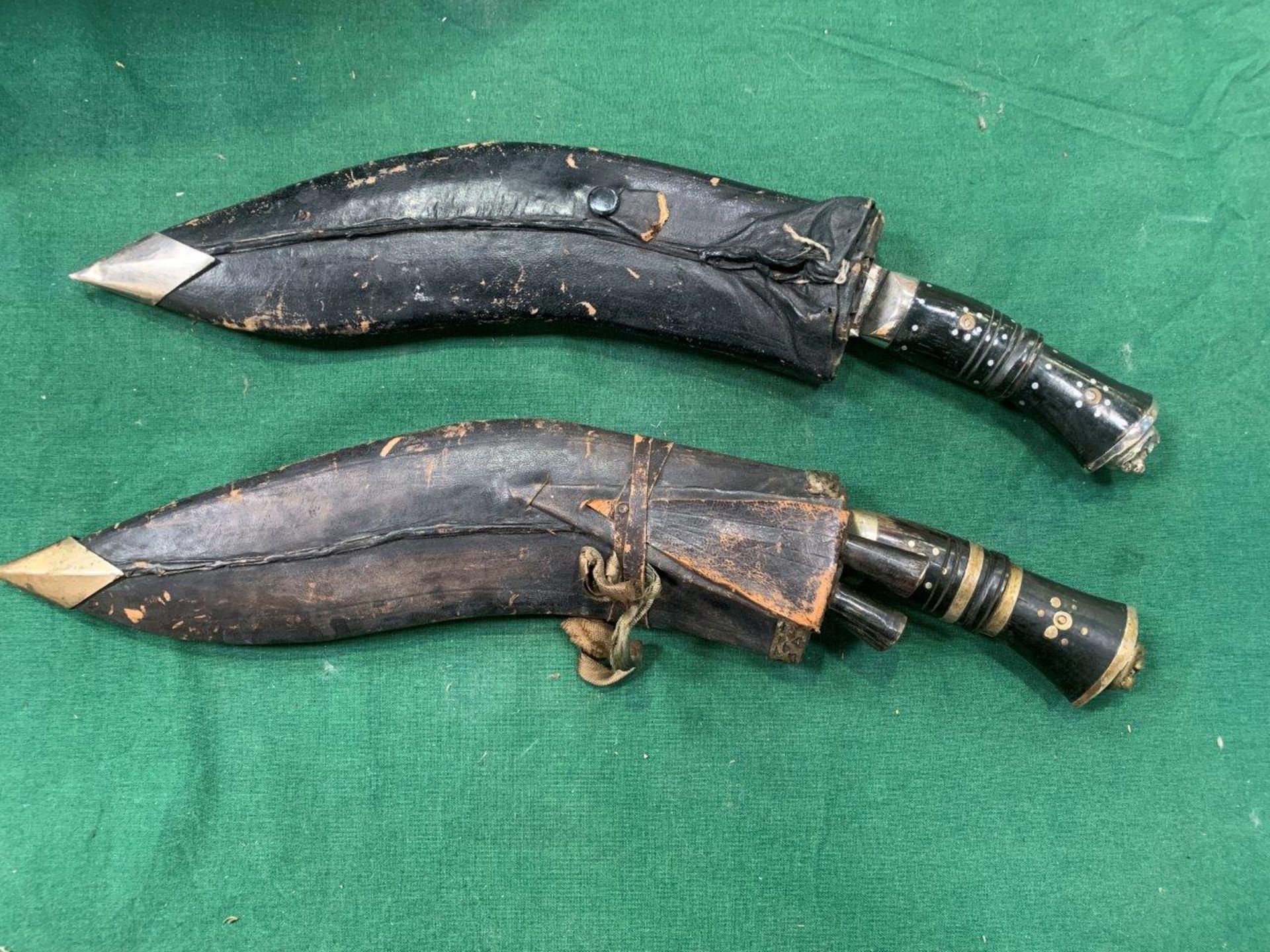 Two Kukri knives in leather and wood sheathes