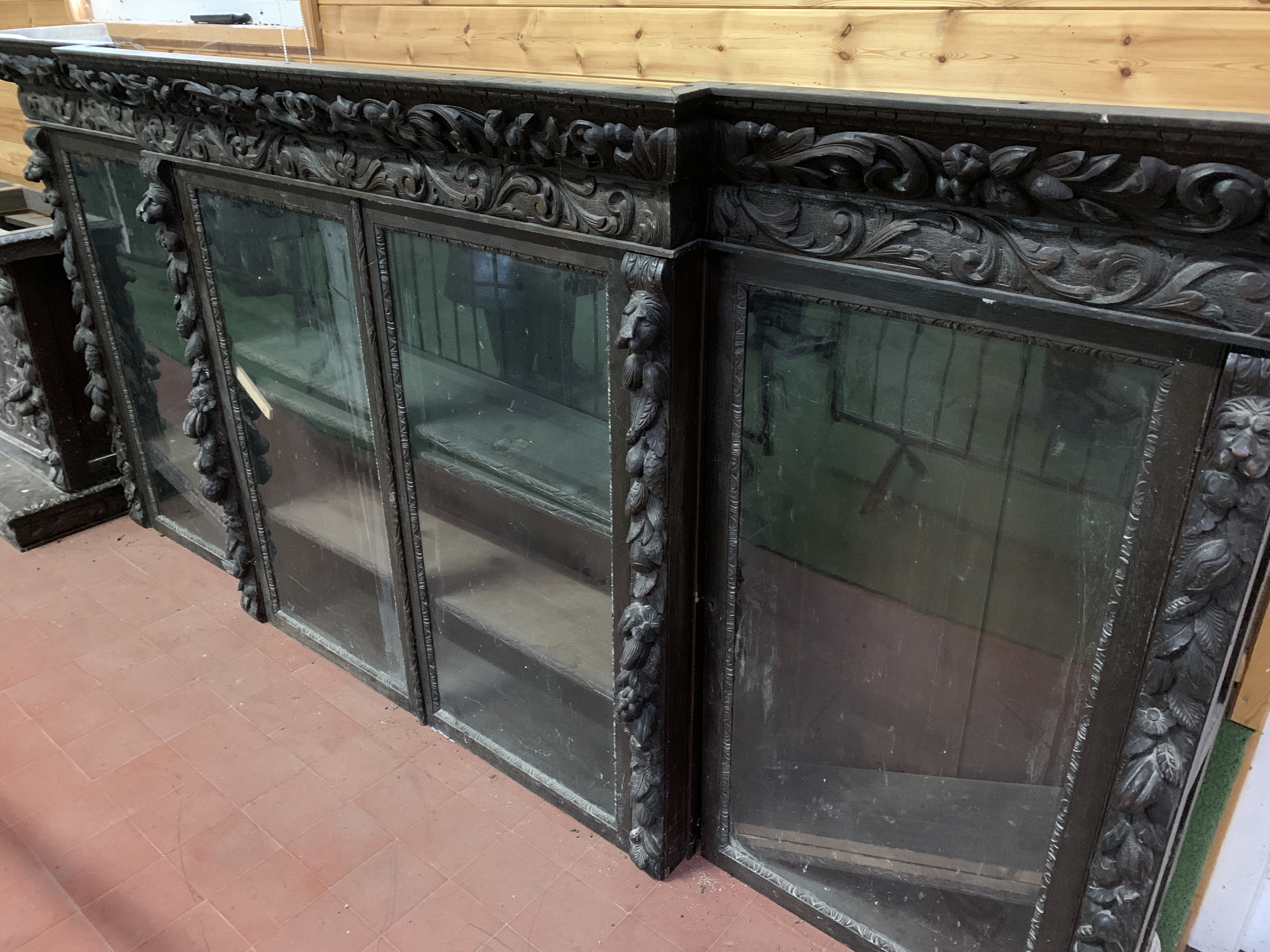 Victorian heavily carved glazed bookcase over four cupboards