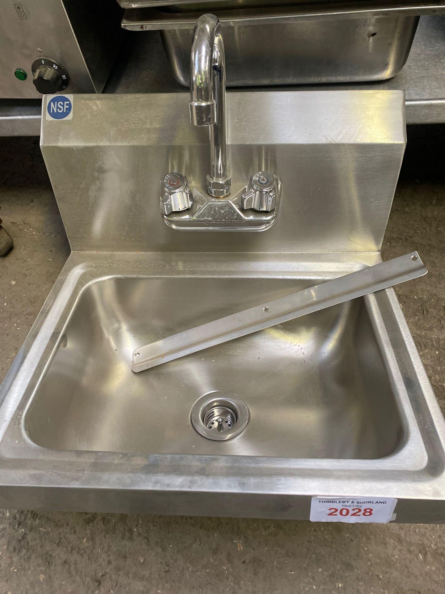 Stainless steel hand sink with tap.