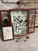 Mahogany display cabinet with glazed doors containing a collection of antique Veterinary equipment.