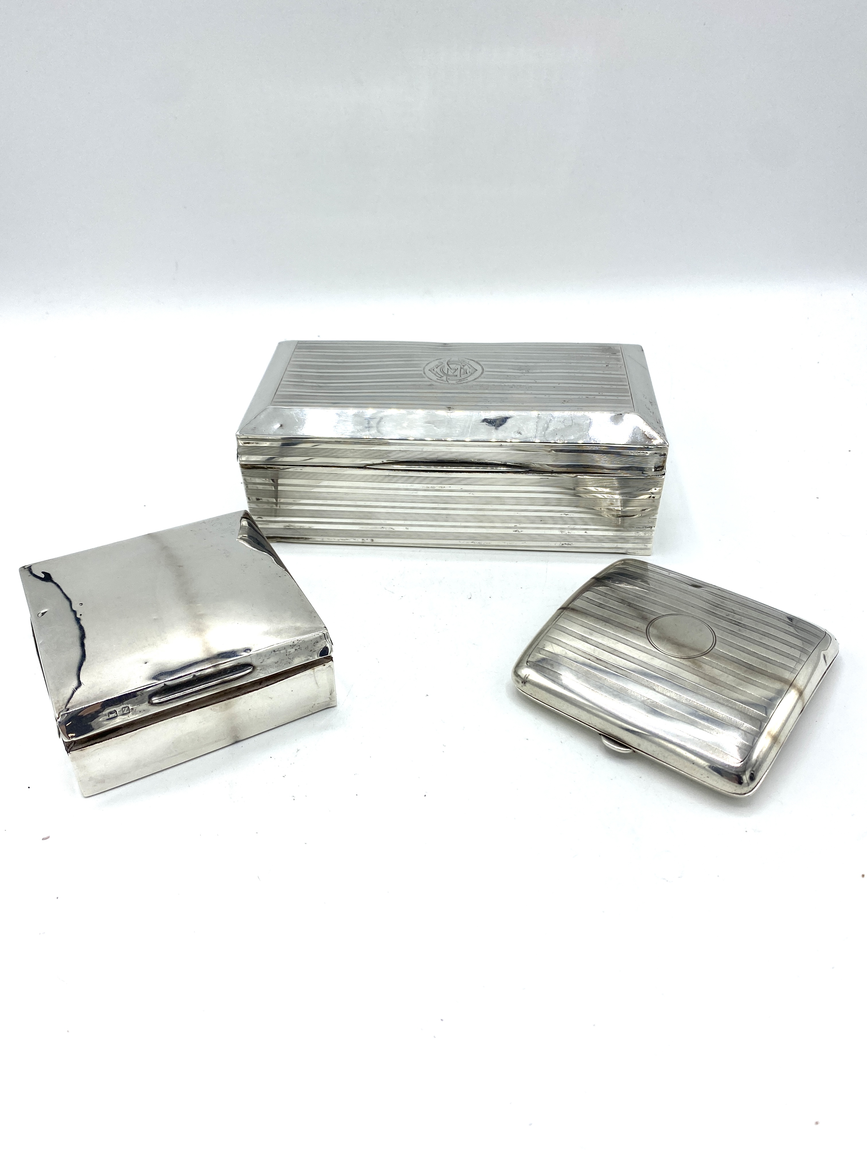 Two silver cigarette boxes and a silver cigarette case
